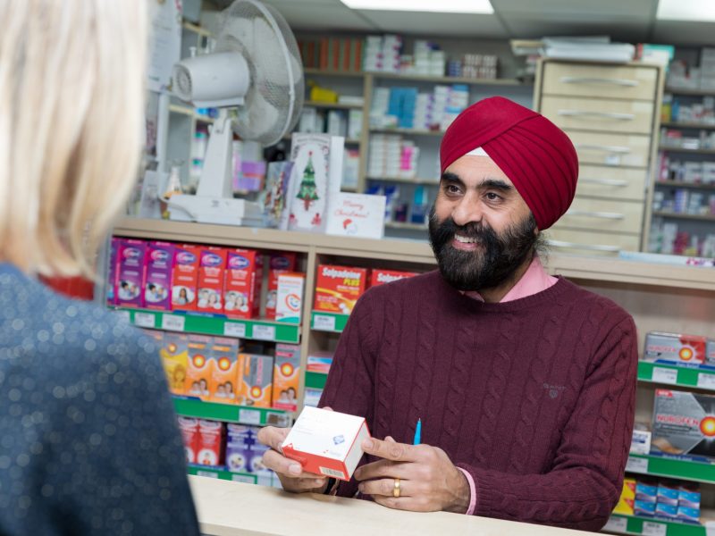 A pharmacist at Teddington Pharmacy talks with a customer
