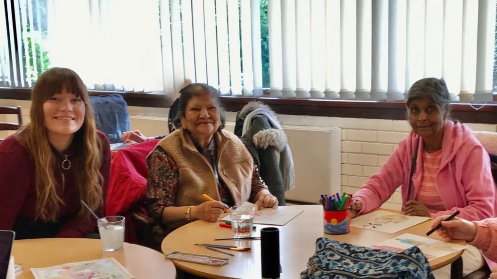 Drama practitioner Daisy Barrett-Nash chatting and colouring with with members of the Merton Plays group at New Horizon Centre, Pollards Hill. 