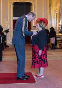 Christine receiving her MBE from Prince William.