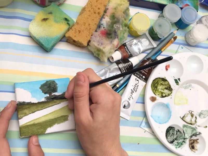 Artist at work on small landscape