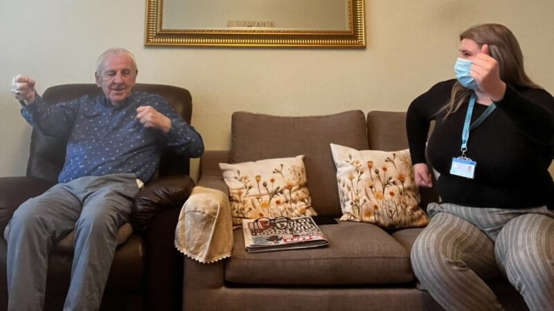 A Community Exercise Volunteer helping a patient with his rehabilitation exercises in his own home