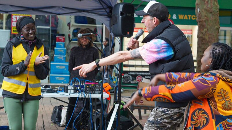 People singing and dancing at a stall for Croydon learning disability carnival