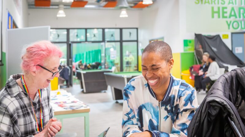 Two women sat at a table laughing