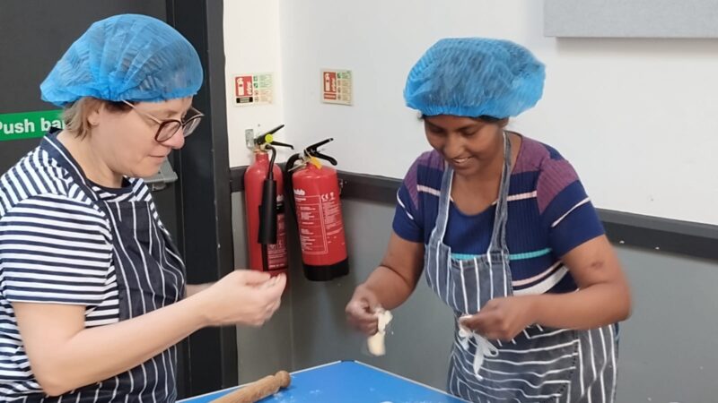 Two women preparing food in a cooking class