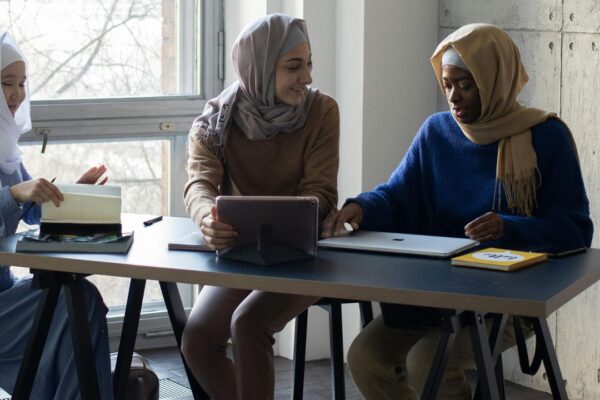 young Muslim women talking around a table