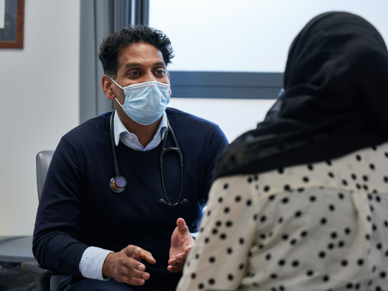 Merton GP Dr Mohan Sekeram talking with a patient