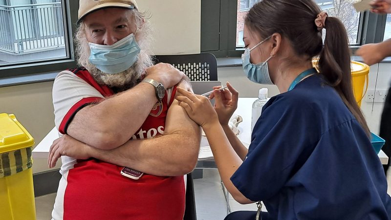 A man being vaccinated at the Kingston and Richmond Health and Wellbeing Day for homeless people, asylum seekers and refugees