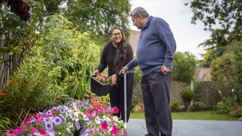 A Personal Independence Coordinator helping a Croydon resident in a garden