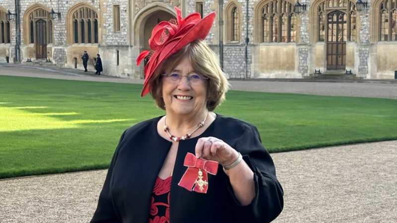 Christine holding MBE medal